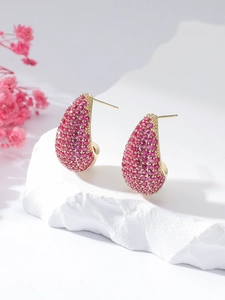 Detail of luxury teardrop earrings featuring pink micro-pave crystals on gold plating
