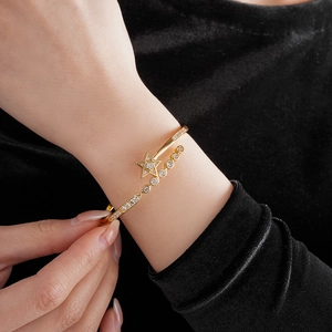 Close-up of gold plated star bangle with zircon stones worn on a model's wrist