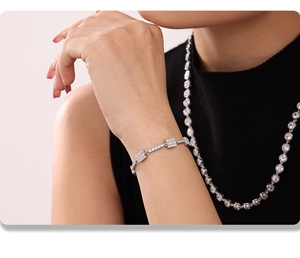 Detail of silver paved zircon bar bracelet and necklace set on a model's wrist and neck