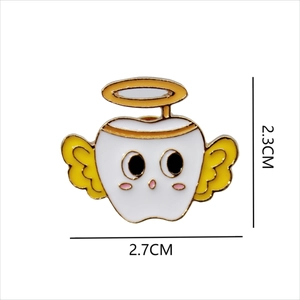 Detail view of cartoon angel tooth metal badge showing size 2.3cm height and 2.7cm width