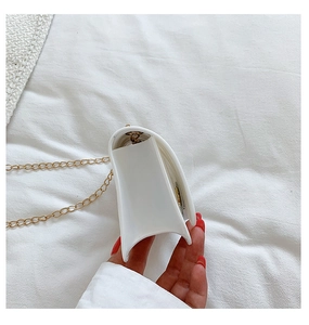 Side view detail of white silicone heart bag showing thick trapezoidal edge and gold chain