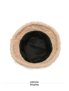 Detail view showing black inner lining and beige faux lamb wool fabric of the bucket hat