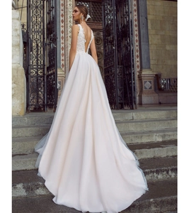 Vue détaillée du dos nu d'une robe de mariée en dentelle blanche avec traîne en tulle