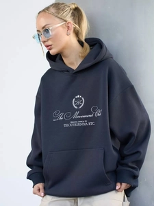 Close-up of oversized navy hoodie with white The Movement Club vintage letter print