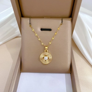 Titanium gold pearl necklace set with clover pendant in a beige jewelry box