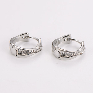 Close-up of silver-tone crisscross hoop earrings set with sparkling zircon stones