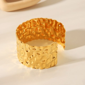 Macro shot of 18K gold plated stainless steel wide cuff with hammered texture finish