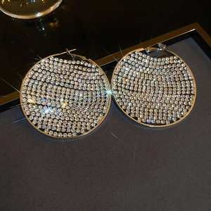 Detailed macro view of large silver geometric hoop earrings with shimmering rhinestones