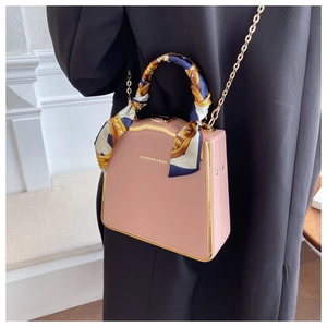 Pink leather box bag with silk scarf wrapped handle and gold chain strap