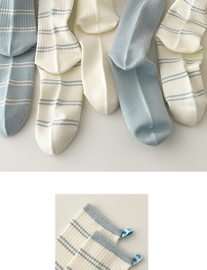 Detail of blue striped knit socks with heart-shaped label and ribbed cuff texture