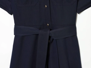 Détail de la taille d'une robe chemisier avec ceinture à nouer et bouton doré