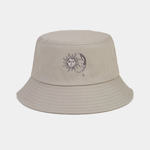 Detail of sun and moon graphic on beige cotton bucket hat with reinforced stitching