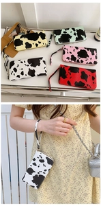 Detailed view of PU leather cow print wallets in multiple colors with wrist straps