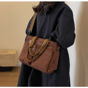 Brown corduroy shoulder bag with multiple exterior pockets and adjustable strap shown on model