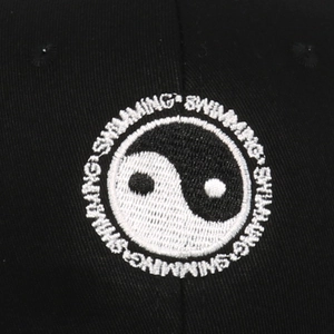 Black baseball cap featuring Tai Chi Yin Yang embroidery and circular text pattern
