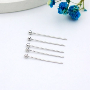 Macro detail of five silver ball head pins for DIY jewelry making on white background