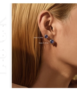 Close-up of model wearing blue round gem earrings in 7mm and 8mm with faceted cut details