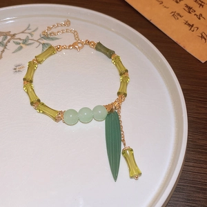 Detail of green bamboo-shaped beads and leaf pendant with gold-plated lobster clasp