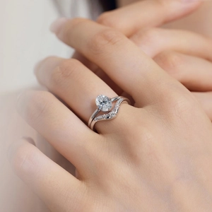 Macro detail of S925 silver wedding ring set featuring oval-cut zircon and curved band