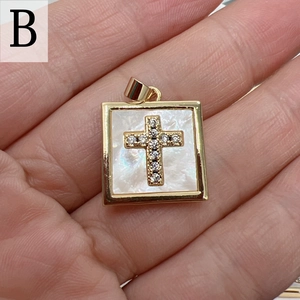 Detail of square gold pendant with white mother of pearl inlay and crystal cross