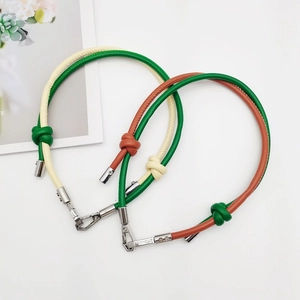 Detail of two-tone leather straps with stylish knotted design and metal buckles