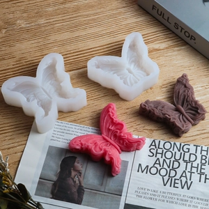 Detailweergave van 3D-vlinder siliconen mal met getextureerde kaarsmonsters in roze