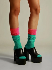 Detail of pink and green color-block slouch socks paired with black platform heels