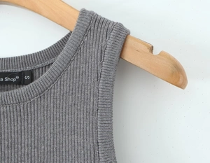 Detail of grey ribbed knit sleeveless top neckline and shoulder with S size label