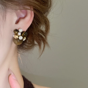 Detailed close-up of vintage flower cluster earrings with brown beads and white pearls