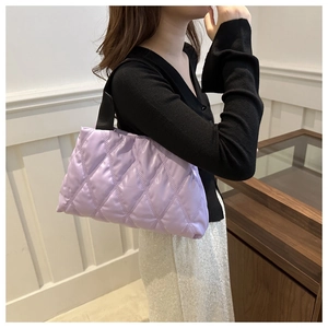 Detail of lavender quilted padded tote bag with soft diamond pattern and black straps