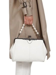 Detailed view of a white crossbody bag with pearl handle and metal kiss-lock closure