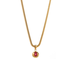 Detail of gold snake chain necklace with rectangular red gemstone pendant on white background