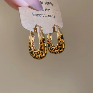 Detail of vintage leopard print square pendant hoop earrings on a paper display card
