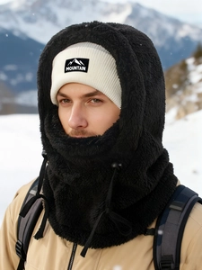 Detail of white knit beanie and black faux fur balaclava for winter outdoor protection