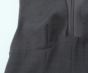 Macro detail of dark grey V-neck dress featuring invisible zipper and refined fabric texture