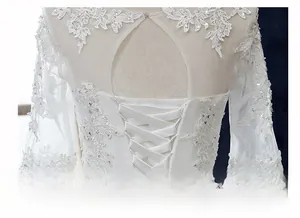 Detailansicht der Rückseite eines Brautkleids mit Spitzenstickerei und Schnürung