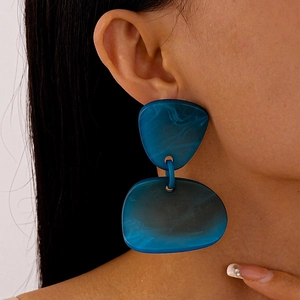 Gros plan sur boucles d'oreilles géométriques en acrylique bleu marine marbré