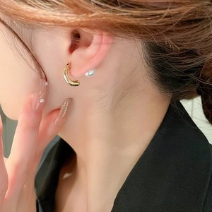 Fashionable gold C-shaped geometric hoop earrings with pearl stud on female model ear