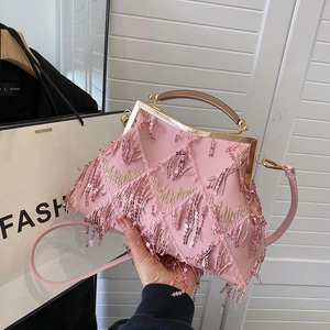 Detail of pink evening bag with sequin fringes and elegant golden metal handle