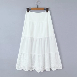 Detail of white tiered midi skirt with intricate hollow embroidery and bohemian lace trim