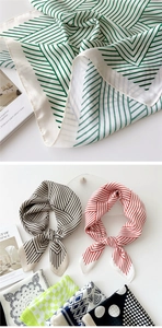 Detailed view of striped silk scarf texture and elegant knotted presentation