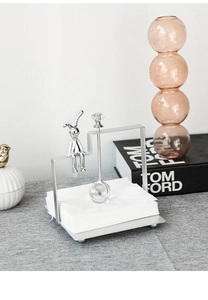 Close-up of a silver bunny napkin holder with a crystal-topped metal weighted arm