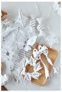 White glittery Christmas pendants set including snowflakes and candies on a white tray