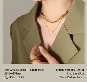 Detail of 18K gold plated titanium stackable chain necklace with pearl and metal square tag