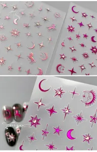 Macro detail of metallic rose pink celestial nail art stickers with tiny rhinestones