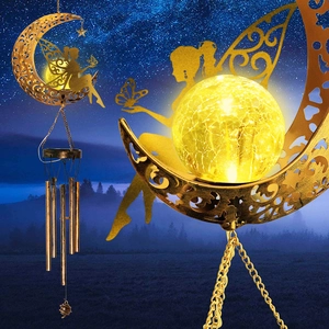 Detail of solar moon wind chime with glowing cracked glass ball and fairy silhouette