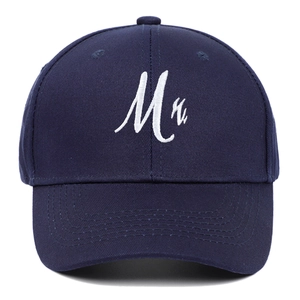 Detailed view of Mr. white cursive embroidery on a classic navy blue cotton baseball cap