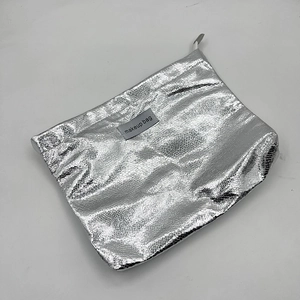 Detailed macro view of the silver metallic PU leather texture and makeup bag zipper
