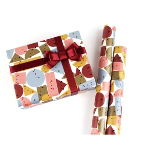 Detail of colorful geometric pattern gift wrap with cute faces and red satin ribbon bow