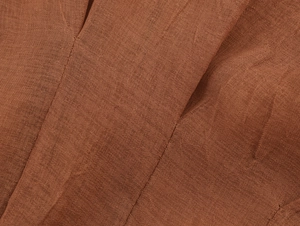 Macro texture view of brown linen-style breathable fabric showing refined woven details